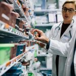 Pharmacists selecting medication from pharmacy shelves