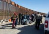 Trump DOJ Takes Border WALL Fight to Supreme Court Group of people standing by a border fence with officers and vehicles