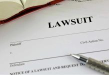 Lawsuit document with a pen and book.
