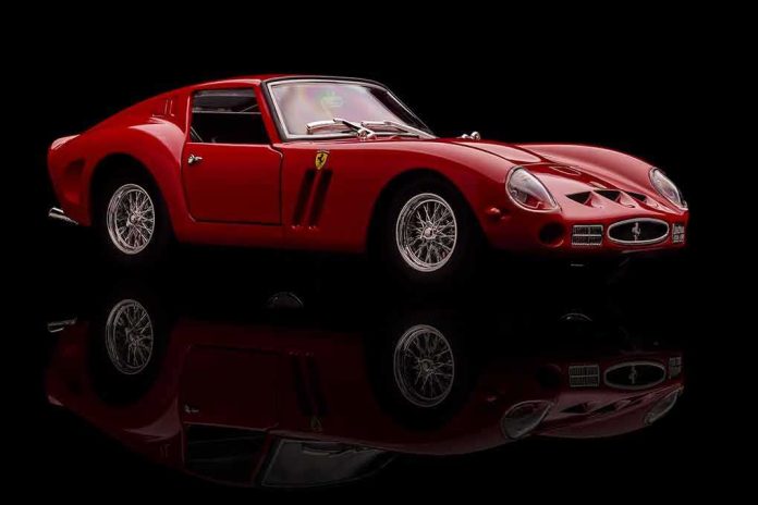 shutterstock_1015435177-1 Red classic sports car on black background with reflection