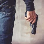 Illegal Opens FIRE on Homeless Camp person holding a handgun by their side