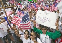 Josh Boyce and crowd at a demonstration waving American flags