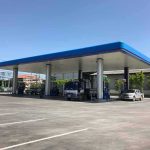 Gas Station DRUG Tied to College Student Deaths Gas station canopy with fuel pumps and vehicles on a clear day