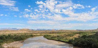 Texas Moves to Lock CARTELS Off Islands River winding through a desert valley under a blue sky