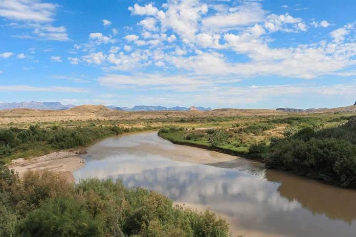 shutterstock_1143125411 River winding through a desert valley under a blue sky