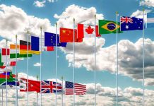 This Country’s Voter Roll Fight Sends Gen Z Into the Streets Row of international flags on tall poles against a cloudy sky
