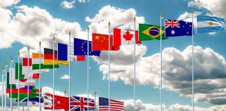 This Country’s Voter Roll Fight Sends Gen Z Into the Streets Row of international flags on tall poles against a cloudy sky