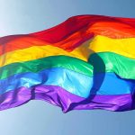 Jesuits REJECT Man Who Questioned LGBT Priest Rainbow pride flag waving against a clear blue sky