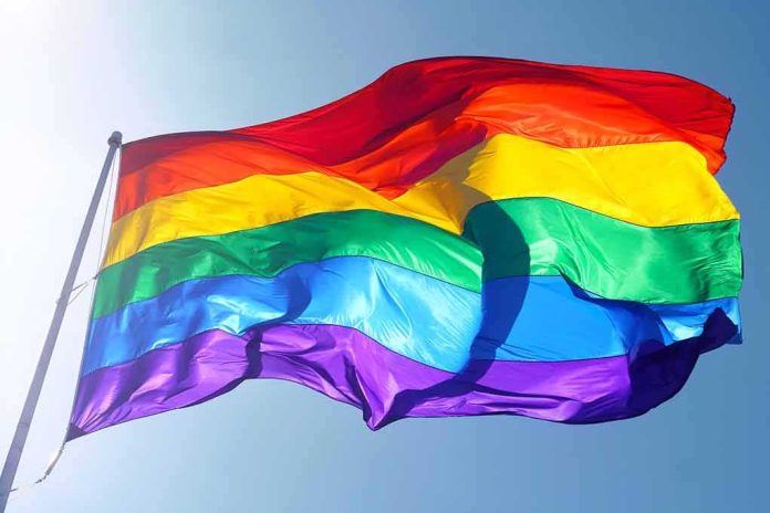 shutterstock_115334458 Rainbow pride flag waving against a clear blue sky