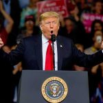 Trump Says He’s Saving MARRIAGES Donald Trump speaking at a rally podium with arms raised