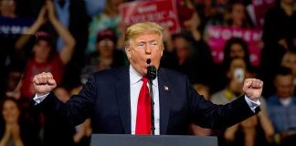 Trump Says He’s Saving MARRIAGES Donald Trump speaking at a rally podium with arms raised