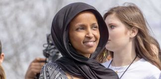Feds Left Ilhan Omar Unable to Phone HOME Ilhan Omar wearing a black headscarf at an outdoor event