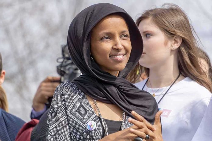 shutterstock_1340333447 Ilhan Omar wearing a black headscarf at an outdoor event