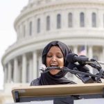 Ilhan Omar Doubles Down on ABOLISHING ICE Woman in hijab speaking at podium with microphones