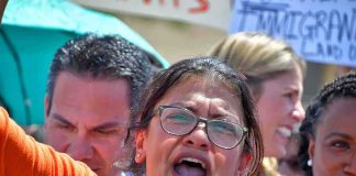 Rashida Tlaib speaking at a rally with Pete Aguilar and Ayanna Pressley in the crowd