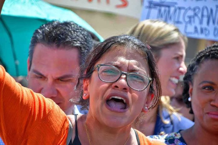 shutterstock_1439792762 Rashida Tlaib speaking at a rally with Pete Aguilar and Ayanna Pressley in the crowd