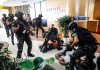 American Among the DEAD in Airport Attack Tactical police detain suspects in an office lobby