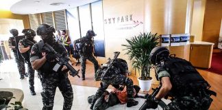 American Among the DEAD in Airport Attack Tactical police detain suspects in an office lobby