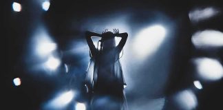 Bush-Bashing Singer Now Goes After TRUMP Silhouetted singer on stage amid dramatic blue spotlights