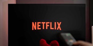 Woke Netflix Is in TROUBLE TV screen with Netflix logo and person holding remote