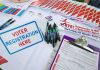 20,000 Suspect Ballots SLIP Past DOJ Voter registration table with forms, pens, and informational materials