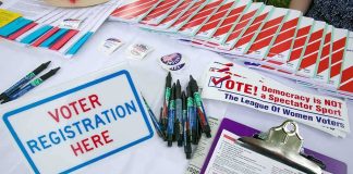 Record Voter FRAUD Raids Hit California Voter registration table with forms, pens, and informational materials