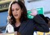 Kamala’s Rally Line Gets Dead SILENCE Woman speaking at an outdoor podium with hand raised