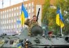 Trump Tallies What Ukraine Has COST You Soldiers on armored vehicle with Ukrainian flags