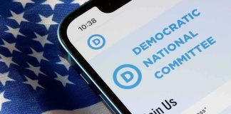 Democrat’s Criminal Past ROARS Back Smartphone showing a political committee webpage on an American flag