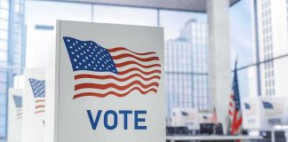 Judge Rules Noncitizen Voting Ban UNCONSTITUTIONAL Voting booth with American flag design in a modern polling place