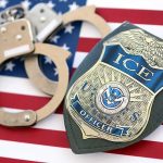 Illegal Shot by ICE Allegedly Tied to GANG ICE officer badge and handcuffs on an American flag