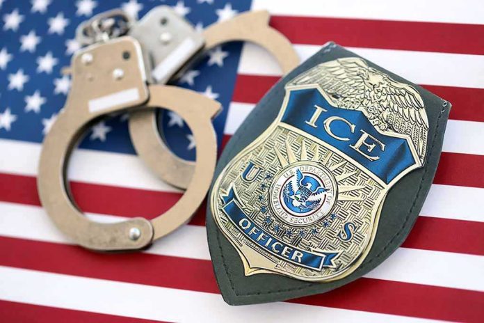 shutterstock_2782818537-1 ICE officer badge and handcuffs on an American flag