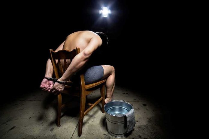 shutterstock_405711415 Handcuffed man on chair in dark room with water bucket