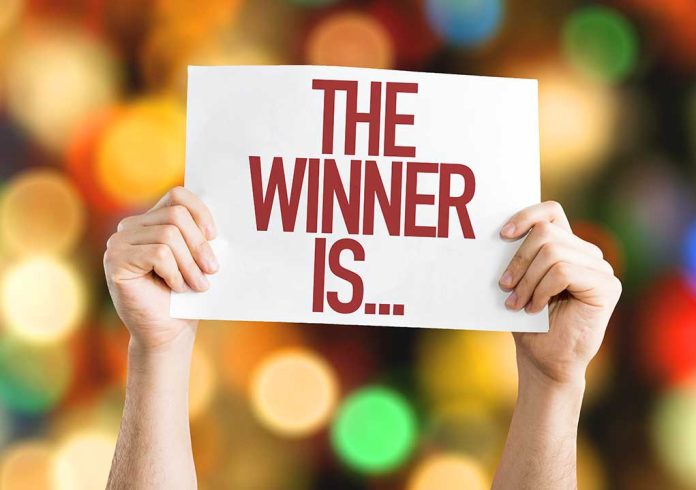 322328513 featured image Hands holding a sign reading "The Winner Is..."