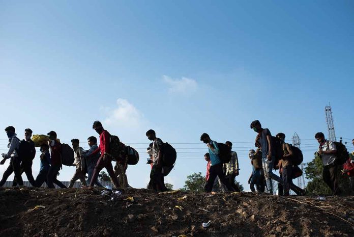 1729141072 featured image Line of migrants