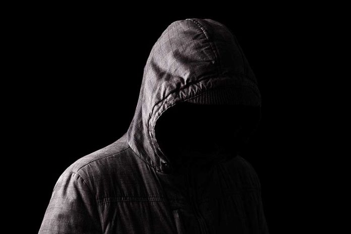1185428734 featured image Person in a hooded jacket, face obscured.