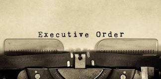 Typewriter typing Executive Order on paper.