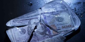 Hundred-dollar bills frozen in cracked ice block