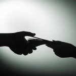 Silhouette of hands exchanging money