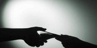 Silhouette of hands exchanging money