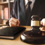 Person in suit with gavel at desk