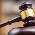 Wooden gavel hitting block in courtroom setting