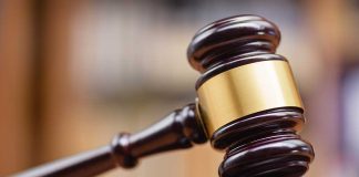 Wooden gavel hitting block in courtroom setting