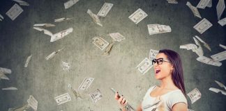 Woman happily holding phone with money flying around