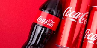 Coca-Cola bottles and cans on red background