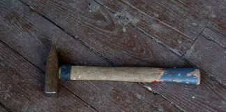 Rusty hammer on a worn wooden floor.