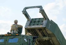 Soldier with military vehicle and missile launcher.