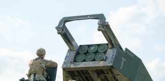 Soldier with military vehicle and missile launcher.