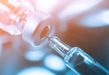 Syringe drawing liquid from a vial