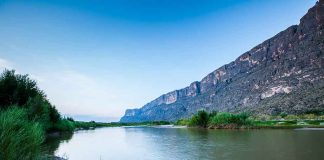 River with mountains and greenery in the background